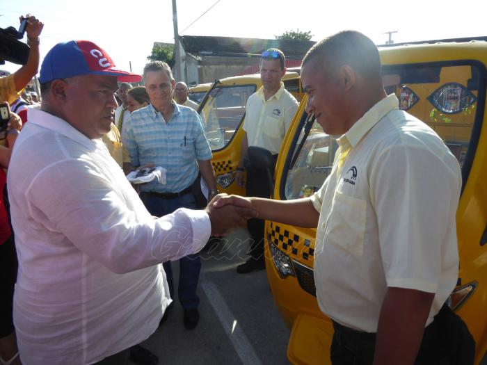 Federico Hernández, primer secretario del Partido en Granma, entrega la llave del vehículo a uno de los diez choferes de los primeros mototaxis que benefician el transporte urbano en la ciudad de Manzanillo, provincia Granma. En ocasión del 26 de julio de 2019, en que Granma es sede nacional.