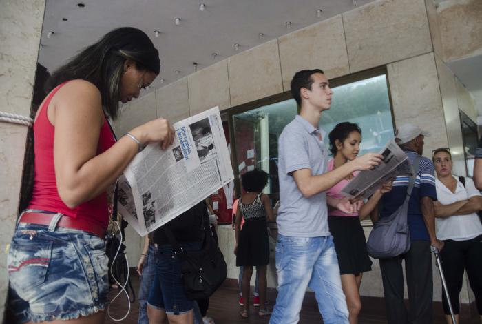 Ambiente de 37 Festival de Cine. En la foto personas leen el periódico del fstival en la entrada del cine Yara, en 23 y L.