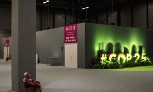 Una mujer sentada en el recinto de la COP 25.