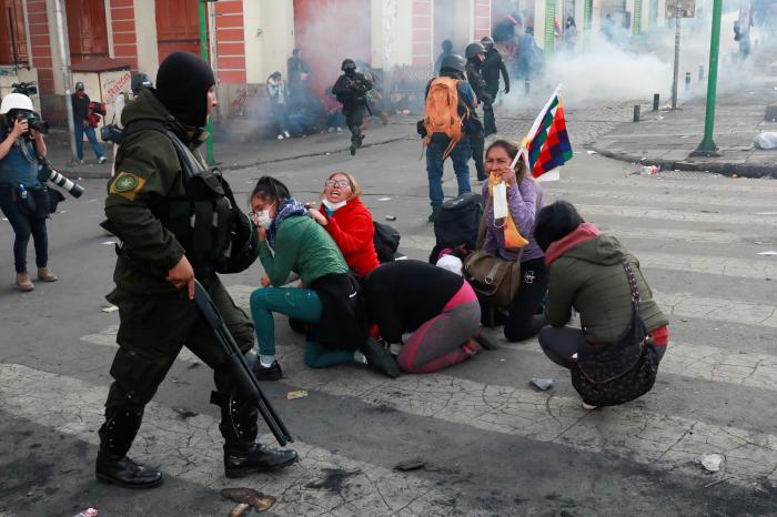 A demonstrator holding a Wiphala flag reacts towards a member of the security forces during clashes between supporters of former Bolivian President Evo Morales and the security forces, in La Paz, Bolivia November 15, 2019. REUTERS/Henry Romero