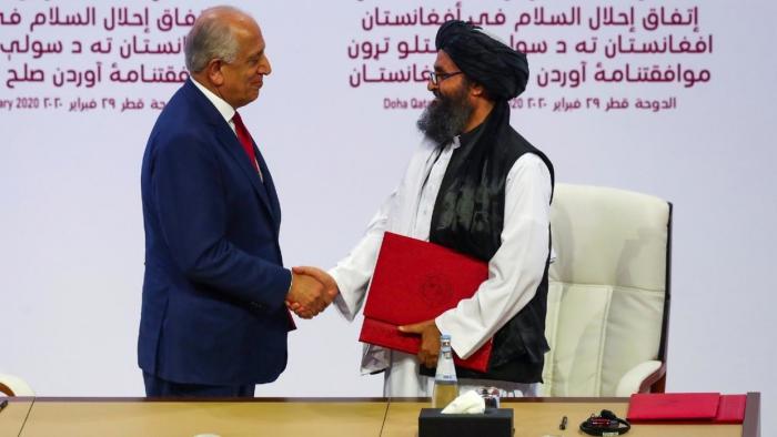 El representante especial de Estados Unidos para la paz, Zalmay Khalilzad, y el líder talibán mulá Abdul Ghani Baradar, tras el primer acuerdo de paz. 