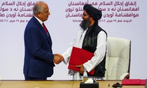 Zalmay Khalilzad, y el líder talibán mulá Abdul Ghani Baradar,