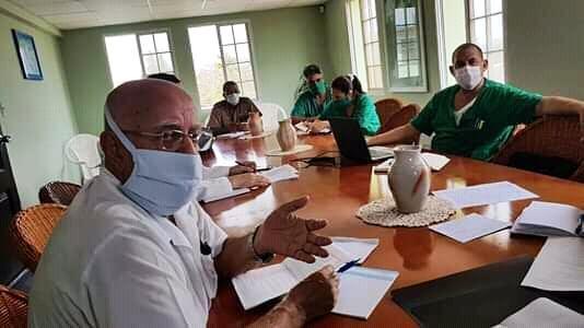 En primer plano el doctor Armando Caballero López, mientras discute los casos graves y críticos en el hospital Manuel Fajardo de Villa Clara. 