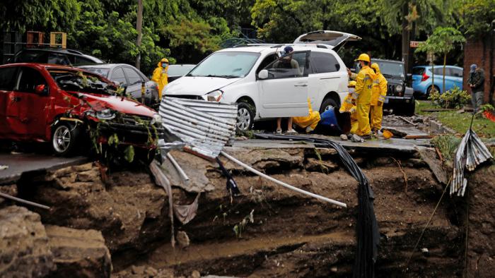 Operarios trabajan en San Salvador (El Salvador) para mover un coche siniestrado 31 de mayo, 2020.