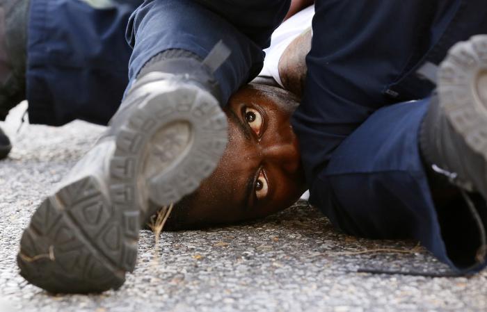 A man protesting the shooting death of Alton Sterling is detained by law enforcement near the headquarters of the Baton Rouge Police Department in Baton Rouge, Louisiana, U.S. July 9, 2016.  REUTERS/Jonathan Bachman     TPX IMAGES OF THE DAY      - RTSH3XY