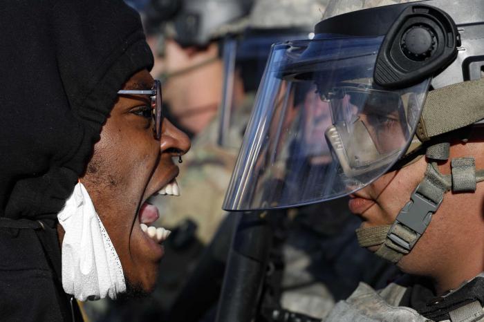 Un manifestante y un agente de la Guardia Nacional se enfrentan en la calle, en Minnesota. Foto: AP