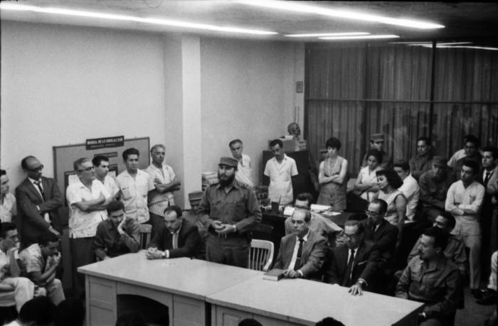 Fidel, junto a integrantes del recién constituido Comité Central del Partido Comunista de Cuba, visita la redacción del periódico Hoy, donde se editaba en esos momentos el primer número del periódico Granma, el 3 de octubre de 1965. En la mesa, de izquierda a derecha, Ramiro Valdés, Isidoro Malmierca, Fidel Castro, Blas Roca, Osvaldo Dorticós y Faure Chomón. Justo detrás de ellos se aprecia a Juan Almeida, Carlos Rafael Rodríguez, Armando Hart y Guillermo García.