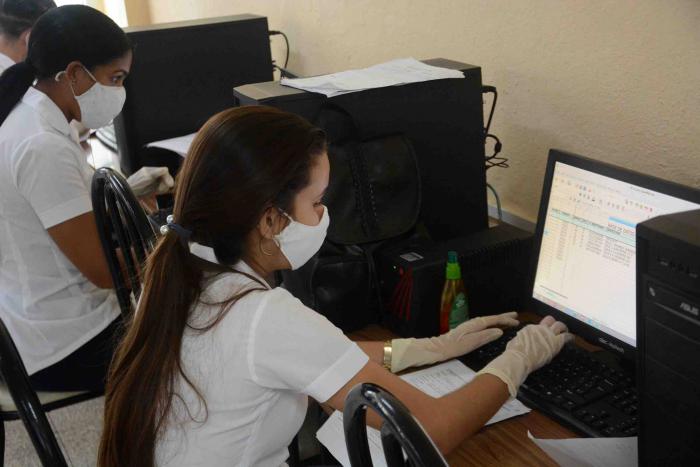 Estudiantes del contingente Centenario por la vida ocupados en la elaboración de los partes diarios