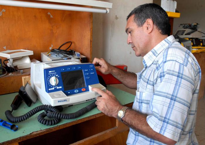 Un especialista del Taller de Electromedicina de la provincia de Camagüey, durante la reparación de un desfibrilador de la marca Philips, una corporación que Estados Unidos multó por vender equipos médicos a Cuba.