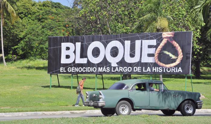 Vehículos por la avenida Boyeros, rumbo a Carlos III. Propaganda condenando el Bloqueo criminal de EEUU a Cuba.