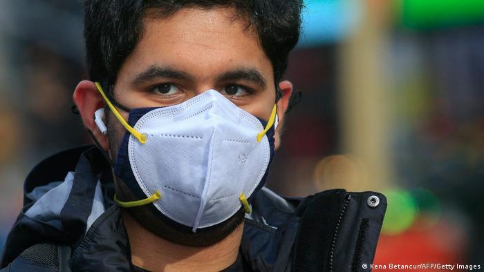 Un joven usando dos mascarillas en Nueva York. Prevención de Covid-19, coronavirus, nasobuco