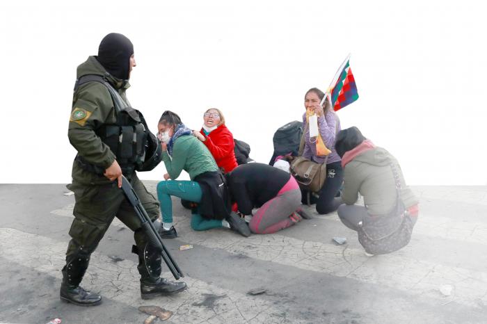 A demonstrator holding a Wiphala flag reacts towards a member of the security forces during clashes between supporters of former Bolivian President Evo Morales and the security forces, in La Paz, Bolivia November 15, 2019. REUTERS/Henry Romero