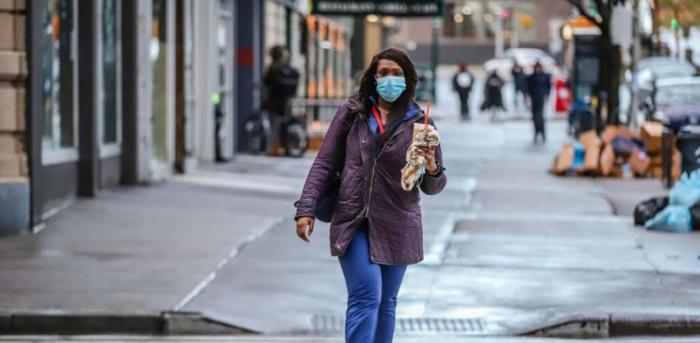Una mujer camina por las calles vacías de la ciudad de Nueva York 