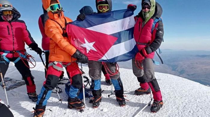 Grupo de Alpinistas con la bandera cubana en el monte Elbrús