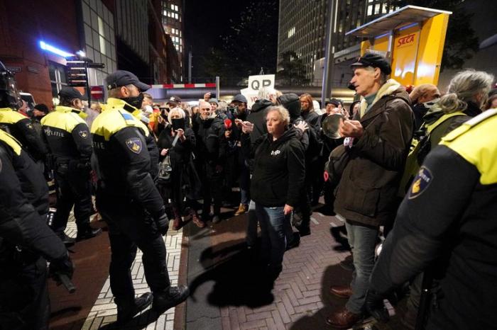 Agentes de policía hacen frente en La Haya a manifestantes luego de que se anunciara la vuelta de la distancia social y las mascarillas a Países Bajos para frenar el auge de contagios de COVID-19