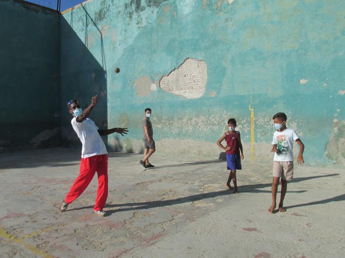 Norge Montalvo, multimedallista mundial, demuestra a los pequeños la manera en que se le pega a la pelota. Obsérvese el mal estado del piso y la pared de la única cancha que Irma no pudo derribar