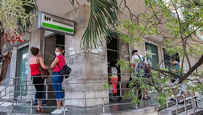 Dos mujeres conversan en la puerta de una sucursal del Banco Metropolitano Prevención contra la Covid-19 – Coronavirus – nasobuco