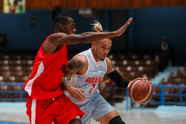 Yasser Rodríguez, de Ciego de Ávila, ataca el aro frente a la defensa de Artemisa durante la primera ronda de la Liga Superior de Baloncesto (LSB)