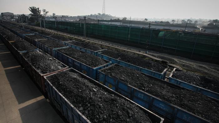 Un tren cargado de carbón en una estación de ferrocarril de la India