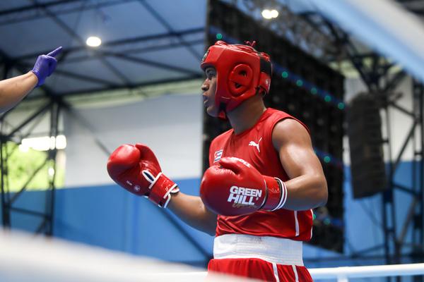 Adrián Fresneda (rojo), de Cuba, recibe conteo de protección durante su combate frente a Marlon Hurtado, de Colombia, en la semifinal de los +91 kg del Boxeo 
