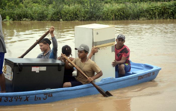 Pobladores rescatan sus bienes personales como consecuencia del desbordamiento del río Yara en la provincia de Granma. FOTO: ARMANDO ERNESTO CONTRERAS