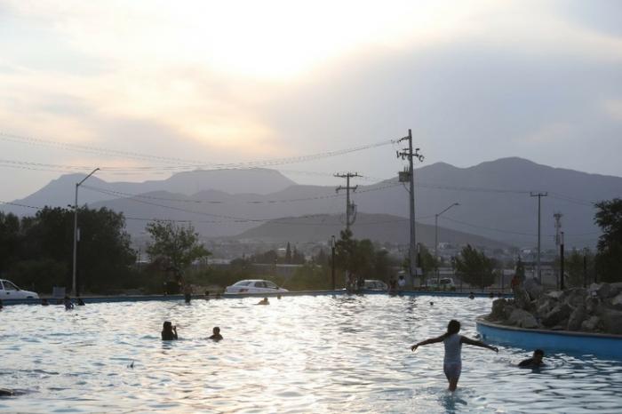 Los mexicanos de Tamaulipas buscan refrescarse del calor en una de las fuentes ornamentales de la ciudad. 