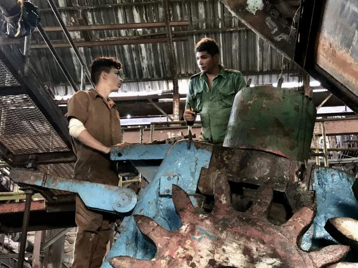 Varios jóvenes trabajan en las reparaciones industriales del central 14 de Julio, situado en el municipio de Rodas