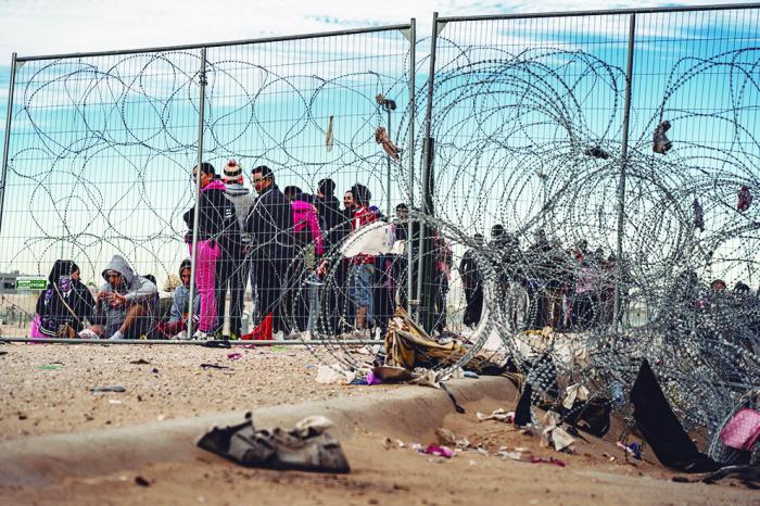 Un grupo de 30 personas migrantes que cruzaron el Rio Grande, esperan en territorio estadounidense, ser detenidos por agentes de la patrulla fronteriza en la puerta 36 del Paso Texas. Foto: Duilio Rodríguez