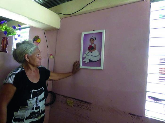 Alicia: «la foto de mi nieta fue la única que libró»; más abajo, la marca que dejó el agua. 