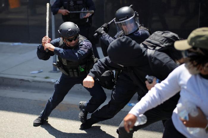  	
Agentes de la Policía Metropolitana de Los Ángeles blandieron sus porras contra los manifestantes durante una protesta contra las redadas federales de inmigración en Los Ángeles el domingo