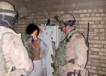Mayo del 2003: Fuerzas especiales de la Marina de Estados Unidos maltratan y humillan a un prisionero iraquí. Foto: AP