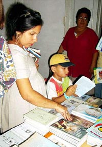 Yenis y su hijo encuentran tesoros en los estantes tuneros. Foto: PASTOR BATISTA VALDS