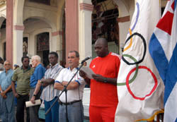 Pedro Luis Lazo, estelar lanzador del equipo Cuba, da lectura al mensaje del COI, flanqueado por las enseas nacional y del COI. Foto: RICARDO LPEZ HEVIA
