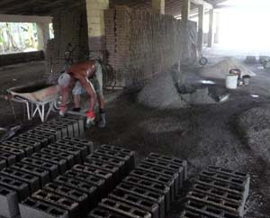 Cada hombre produce manualmente 130 bloques de hormign en medio da. Foto del autor