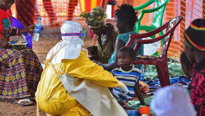 Medici Senza Frontiere (MSF): un lavoratore alimenta un bambino con il virus dell’Ebola in un centro di MSF a Kailahun, a est della Sierra Leone, il 15 agosto del 2014. AFP Photo: Carl De Souza.